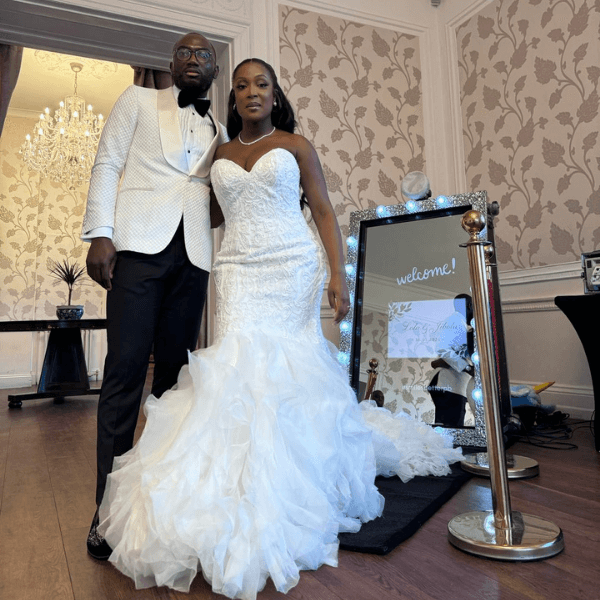 Bride and groom enjoying Magic Selfie Mirror photo booth at wedding reception